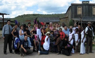 Chicago and Durango students and teachers posing on the dirt street of an old western film set in Durango